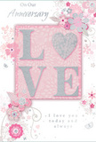 In this image, a tender anniversary card is presented as though it were a delicate floral arrangement on paper, echoing the soft romance of pastel bouquets found in Erith. At the centre of the design, the word LOVE is rendered in raised, glittered letters that shimmer with a mix of blush pink, pearlescent white and fine silver. The texture appears gently grainy and inviting, suggesting a pleasant, tactile sensation as fingers move across each curve and line. Notably, the letter O transforms into a shimmering heart, its silver-toned glitter a touch brighter, creating a focal point that feels quietly celebratory rather than showy. Around the central word, clusters of blossoms unfurl with an almost watercolour softness, their petals tinted in blush, mauve and soft ivory. The outlines are fine and flowing, like the natural arcs of stems in a loosely tied bouquet, and the shading is delicate, giving each flower a sense of depth without making the composition feel heavy. Slender vines weave between the blossoms, forming curls and loops, while tiny decorative details-swirls, petal shapes and subtle butterfly silhouettes-add movement and charm. The background is a calm, powdery pink, reminiscent of the gentle hues seen in the sky above Erith's riverside paths at dusk. In graceful script, the phrases On Our Anniversary and I love you today and always appear, their letters smooth and balanced, echoing the softness of the florals. The card as a whole radiates intimacy and warmth, the sort of keepsake a couple in Erith might treasure beside a vase of anniversary flowers chosen with care.